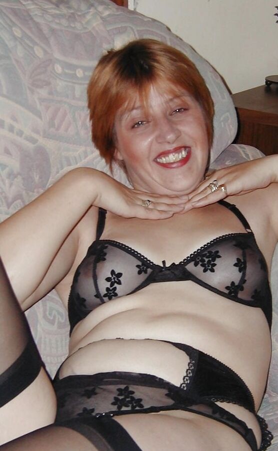 Younger mature Ginger undresses and displays pert breasts
