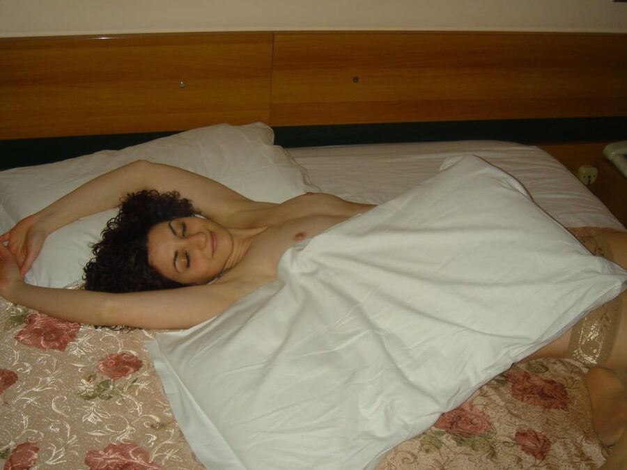 European brunette amateur wearing shiny tan stockings on bed