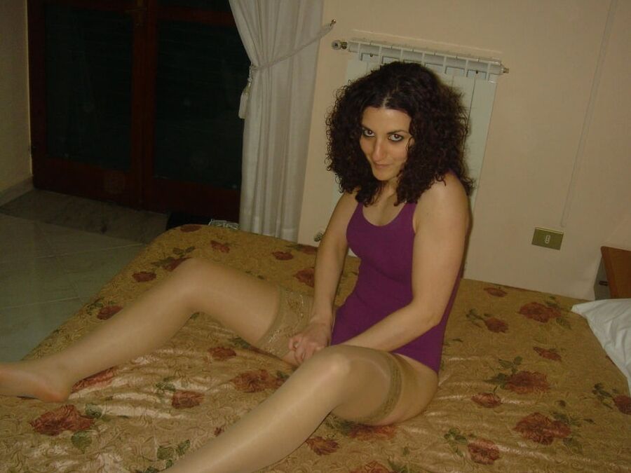 European brunette amateur wearing shiny tan stockings on bed