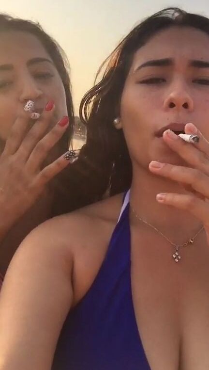 Smoking Kelly Cuesta on beach with lez gf