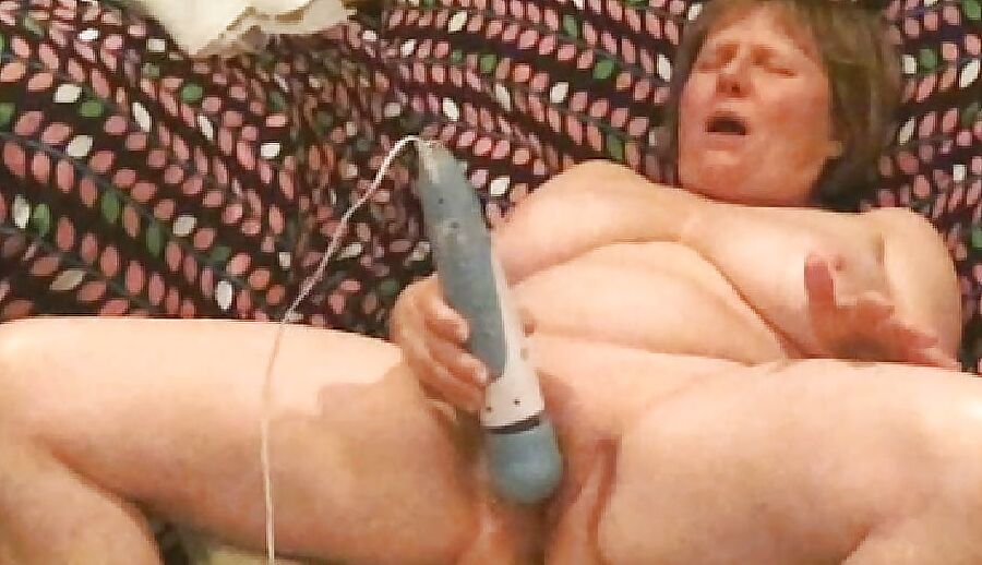 Mom plays with her vibrator in a big chair