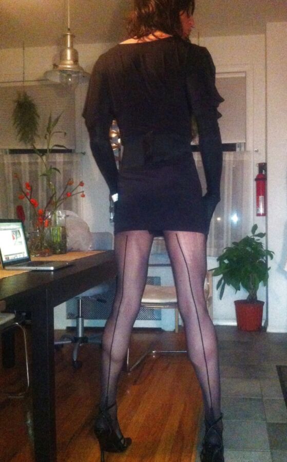 Crossdresser in black party dress, seamed pantyhose