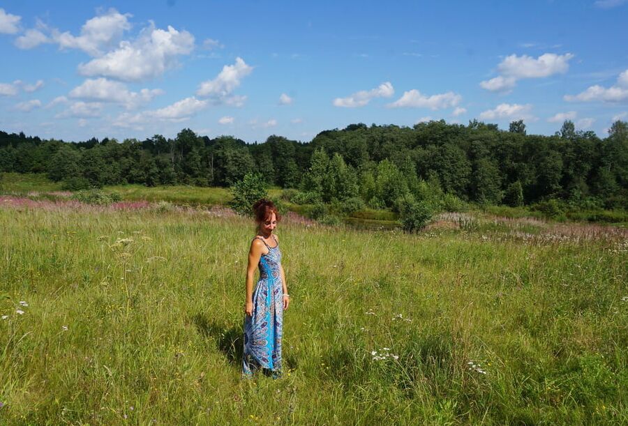 In blue dress in field