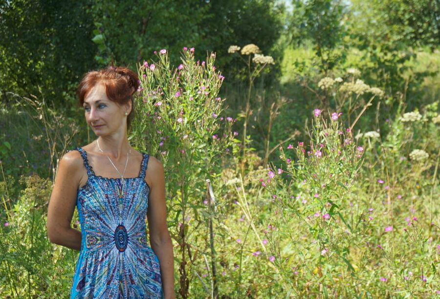 In blue dress in field