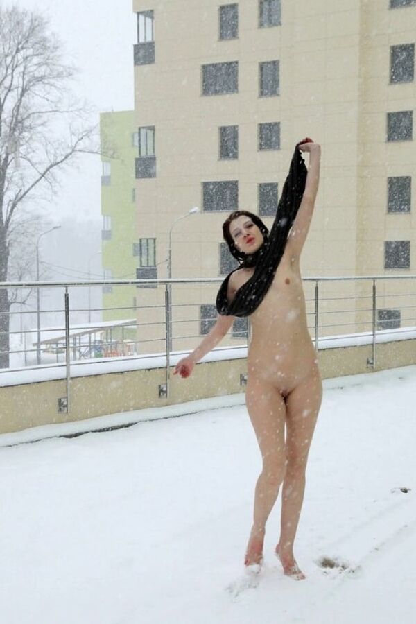Short-haired brunette walks naked at winter streets