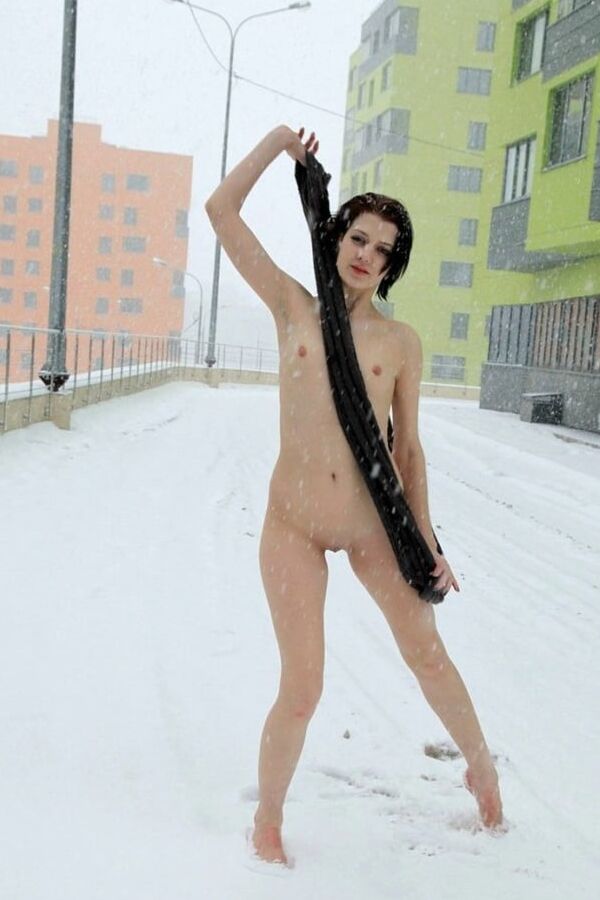 Short-haired brunette walks naked at winter streets