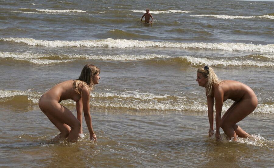 Two sexy girls playing naked on the beach