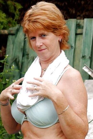 Ginger mature undresses to reveal tits and smooth pussy