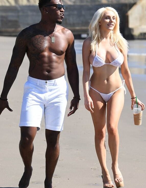 Woman on vacation with black men on the beach.