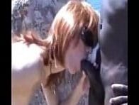 Woman on vacation with black men on the beach.