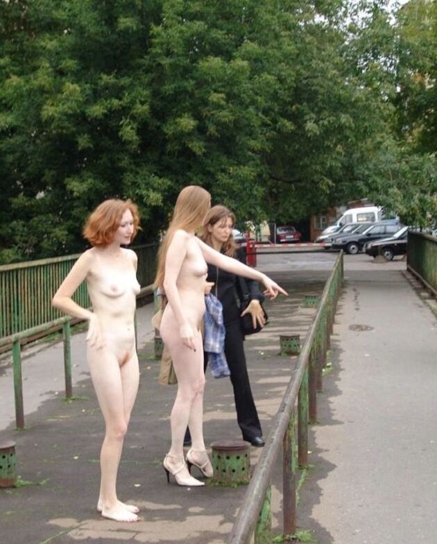 Two completely naked red-haired girls on city streets