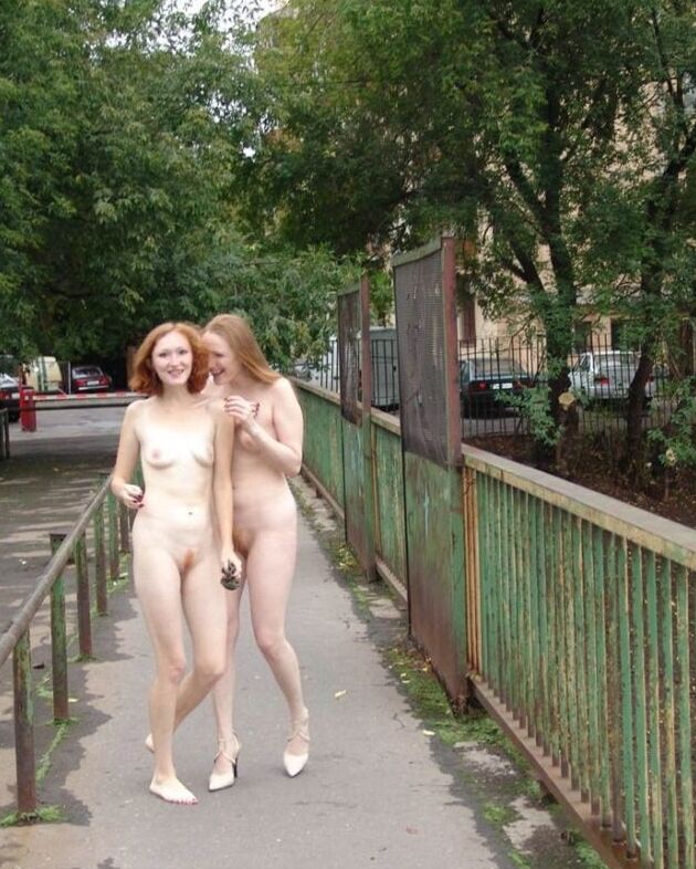 Two completely naked red-haired girls on city streets