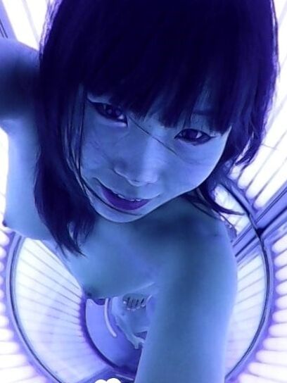 Asian sweetie taking selfies while tanning her body