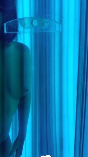 Asian sweetie taking selfies while tanning her body
