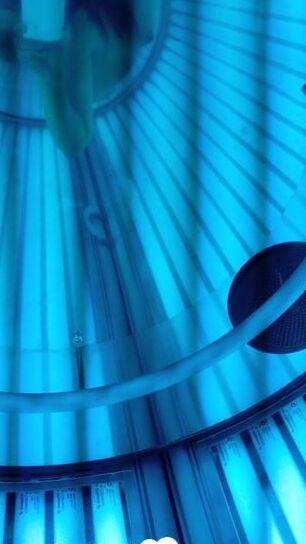 Asian sweetie taking selfies while tanning her body