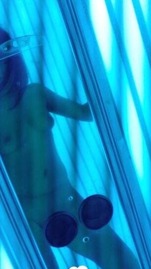 Asian sweetie taking selfies while tanning her body