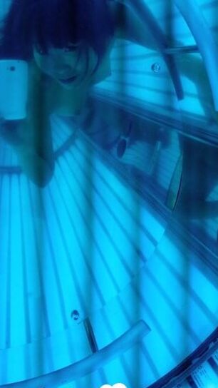 Asian sweetie taking selfies while tanning her body