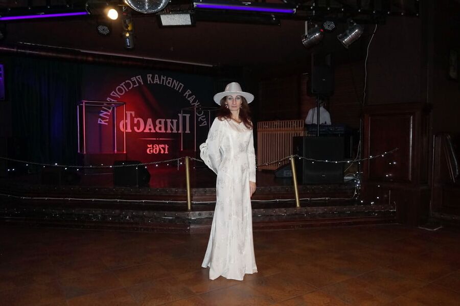 In Wedding Dress and White Hat on stage