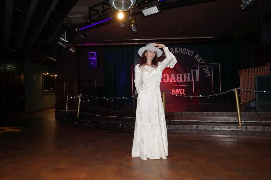 In Wedding Dress and White Hat on stage