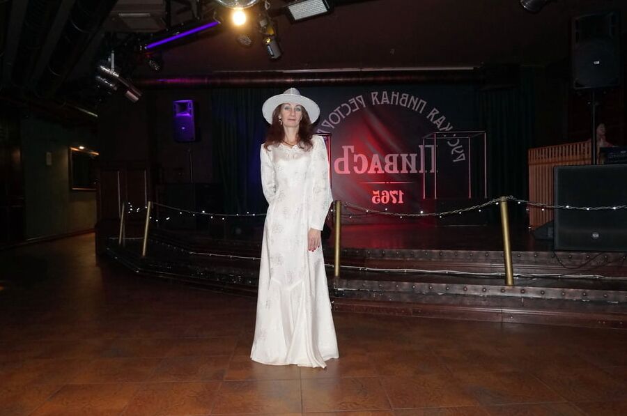 In Wedding Dress and White Hat on stage