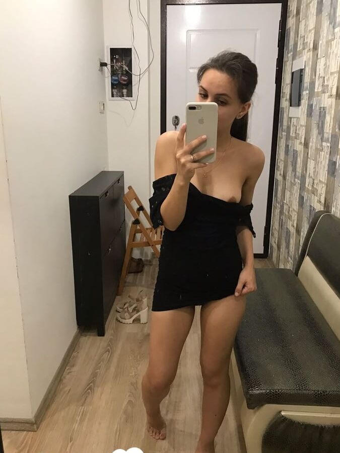 Kinky brunette taking pics while stripping her clothes