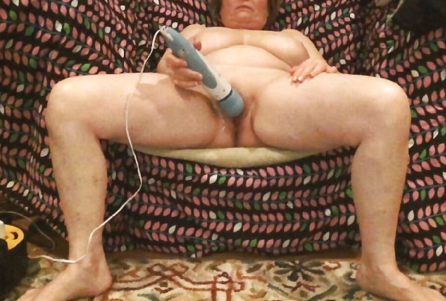 Mom plays with her vibrator in a big chair