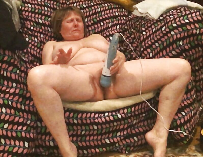 Mom plays with her vibrator in a big chair