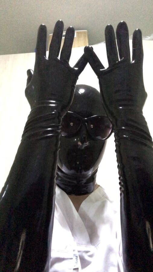Latex mask and black fetish gloves with medical scrubs