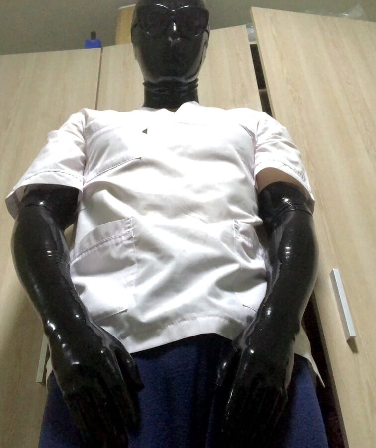 Latex mask and black fetish gloves with medical scrubs