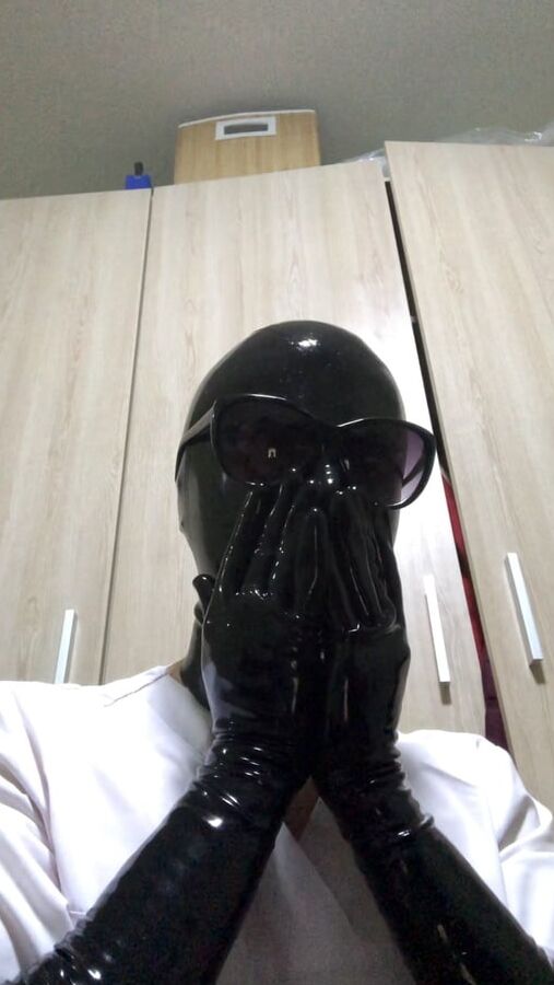 Latex mask and black fetish gloves with medical scrubs