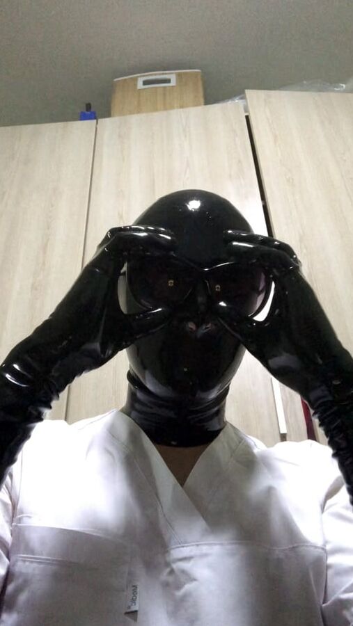 Latex mask and black fetish gloves with medical scrubs