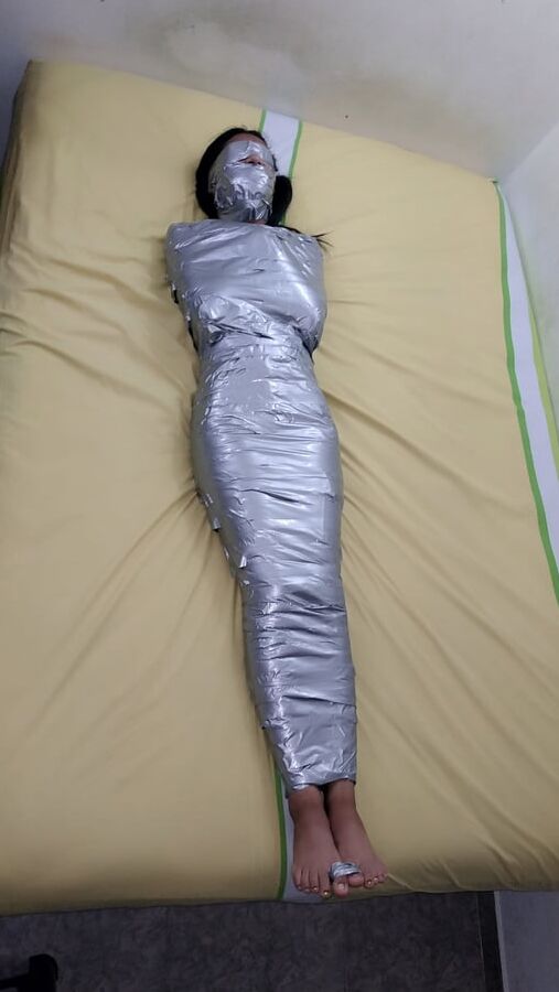 エジプトのミイラのようにダクトテープを巻かれた若い女の子
