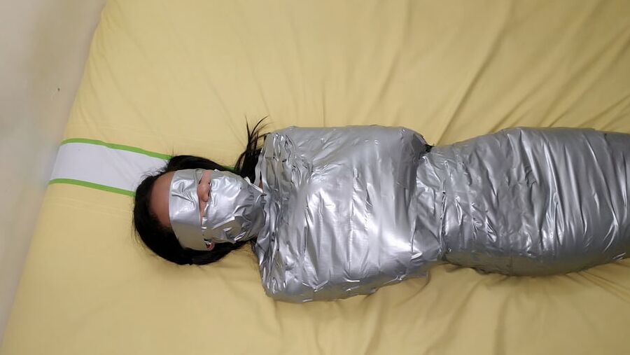 エジプトのミイラのようにダクトテープを巻かれた若い女の子
