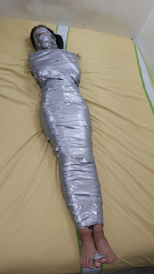 エジプトのミイラのようにダクトテープを巻かれた若い女の子
