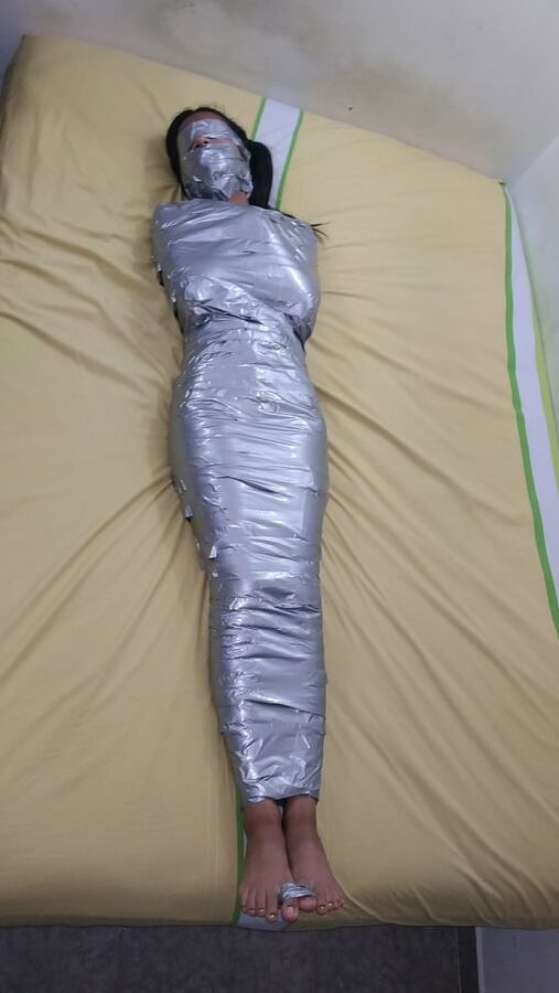 エジプトのミイラのようにダクトテープを巻かれた若い女の子