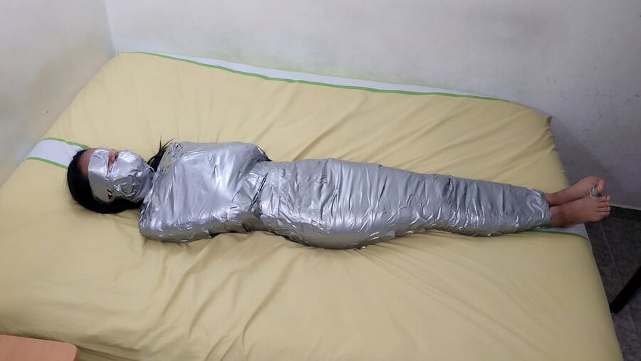 エジプトのミイラのようにダクトテープを巻かれた若い女の子