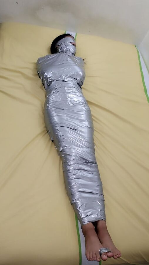 エジプトのミイラのようにダクトテープを巻かれた若い女の子