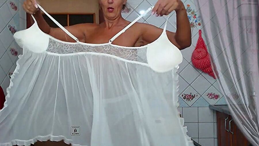 Lukerya in white transparent linen in the kitchen