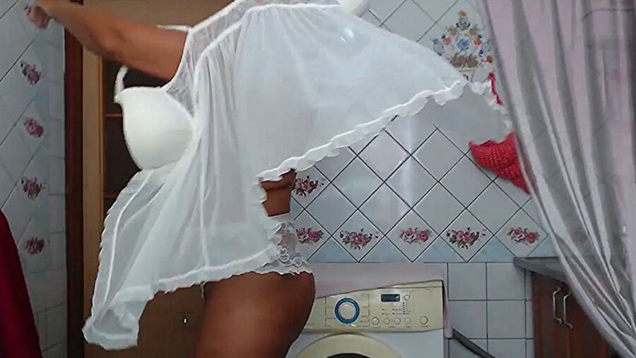 Lukerya in white transparent linen in the kitchen