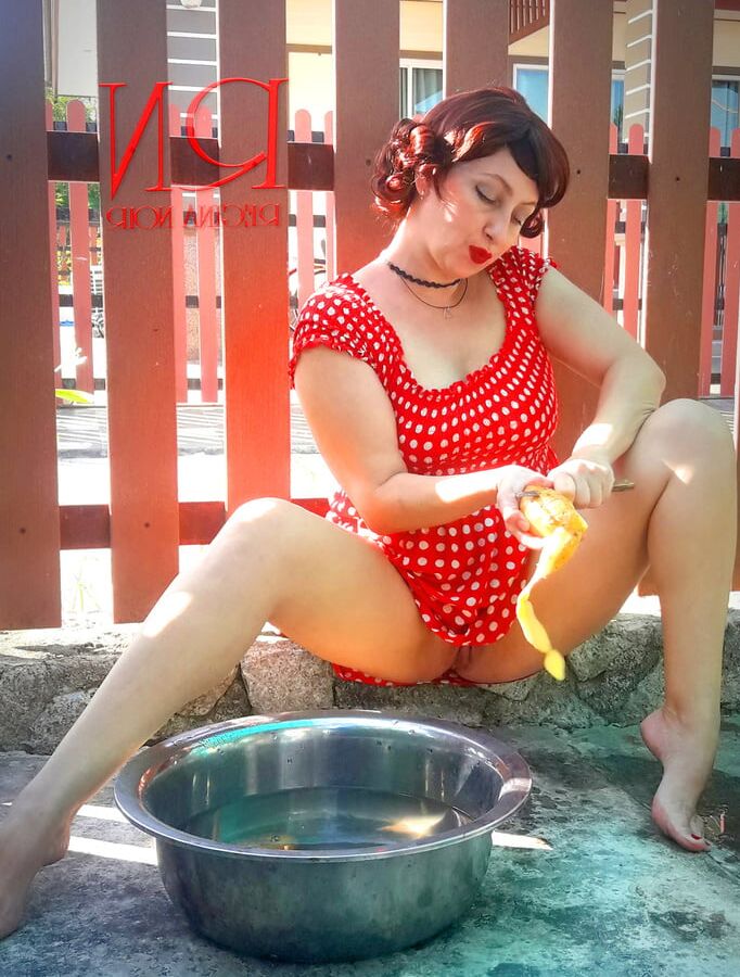 Retro maid prepares potatoes for dinner. Vintage performance
