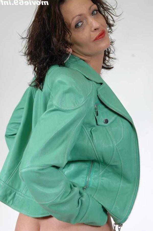 MILF Lea is making up her lips in a green leather jacket