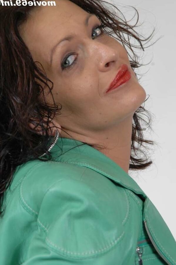 MILF Lea is making up her lips in a green leather jacket
