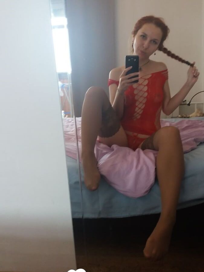 Smoking redhead teases in stockings in the bedroom