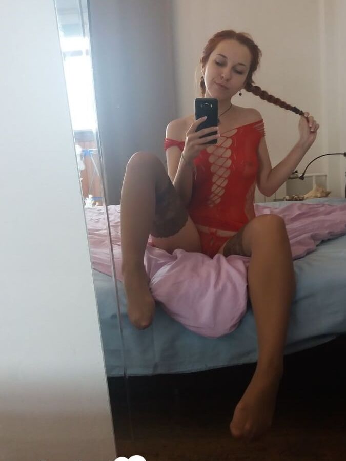 Smoking redhead teases in stockings in the bedroom