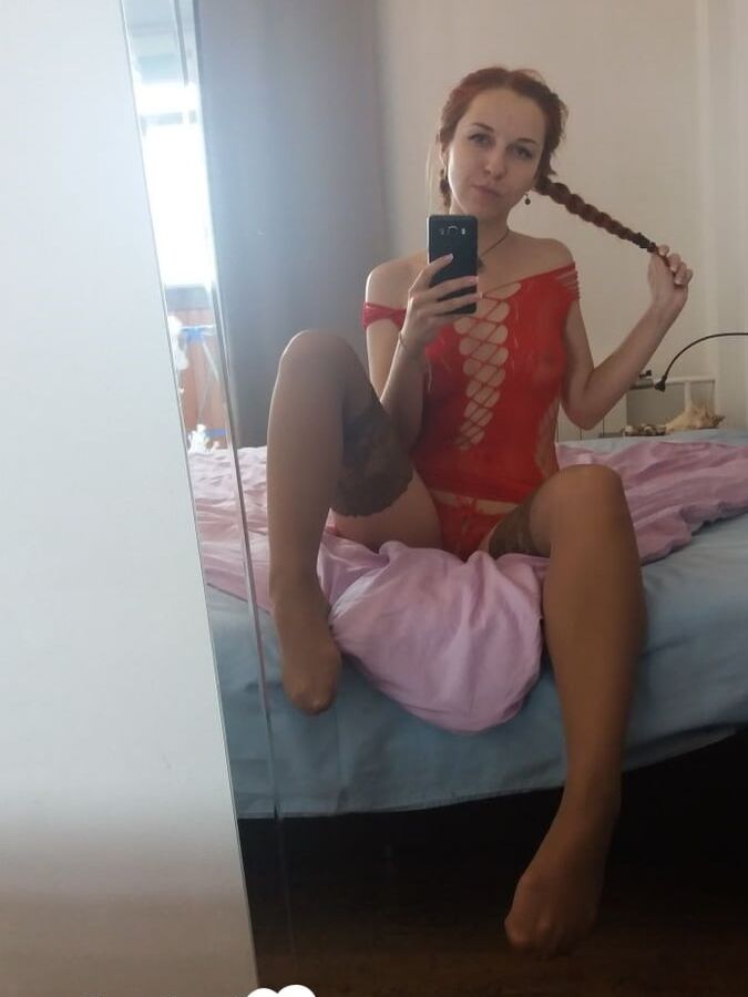 Smoking redhead teases in stockings in the bedroom