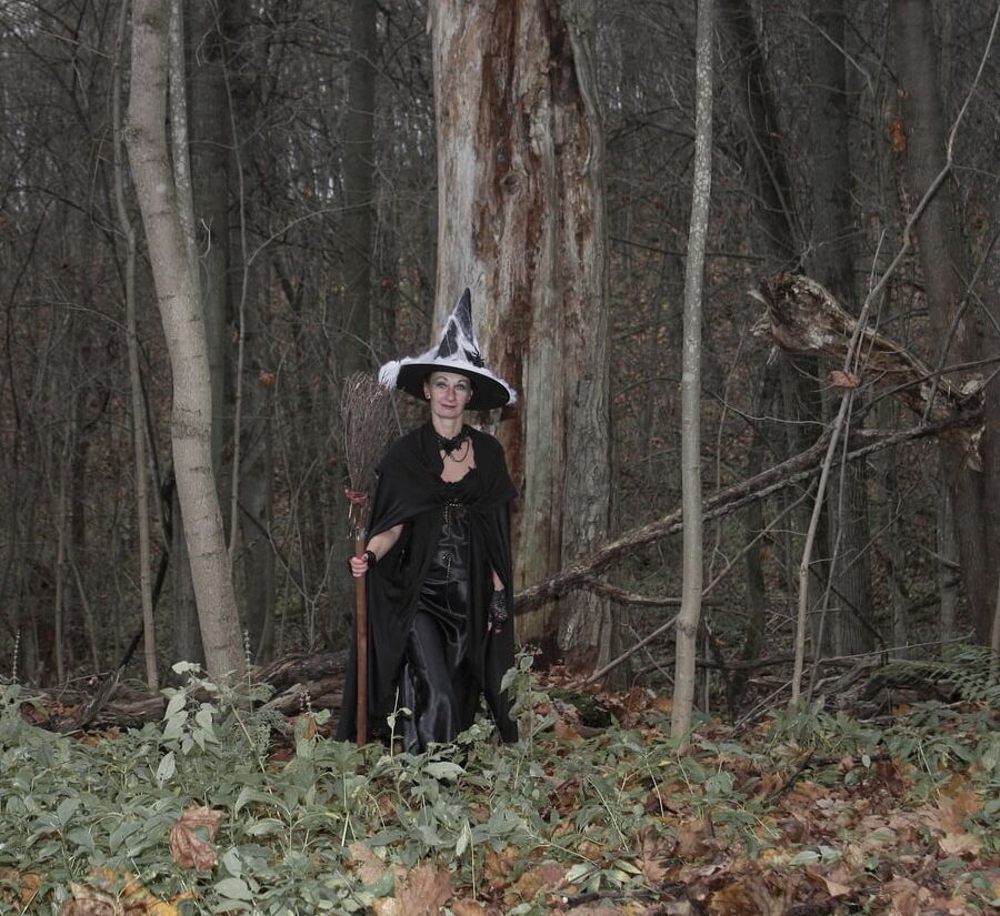 Witch with broom in forest
