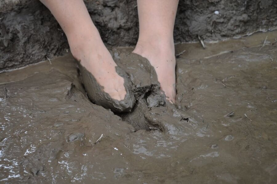 Sexy amateur MILF's feet in tights playing in thick mud