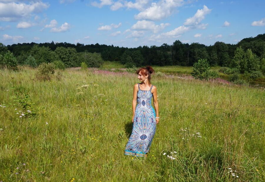 In blue dress in field