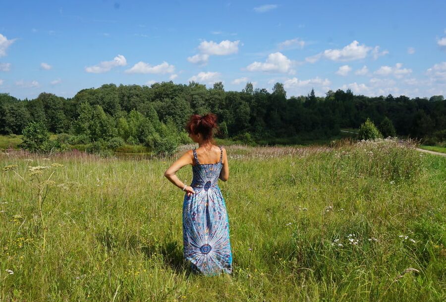 In blue dress in field