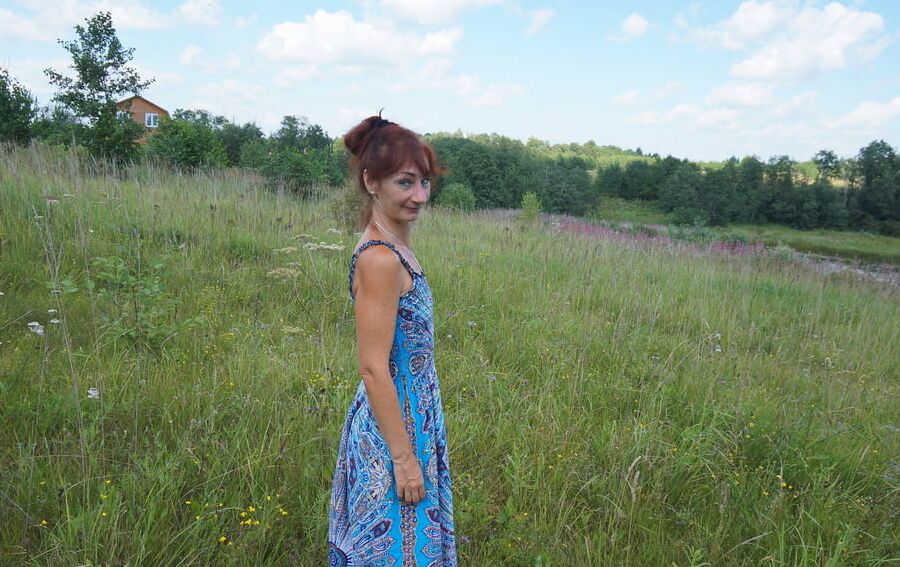 In blue dress in field